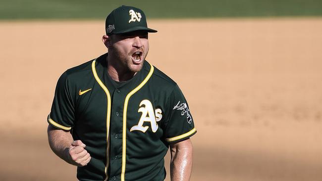 LOS ANGELES, CALIFORNIA - OCTOBER 07: Liam Hendriks #16 of the Oakland Athletics celebrates a 9-7 win against the Houston Astros in Game Three of the American League Division Series at Dodger Stadium on October 07, 2020 in Los Angeles, California.   Kevork Djansezian/Getty Images/AFP == FOR NEWSPAPERS, INTERNET, TELCOS & TELEVISION USE ONLY ==