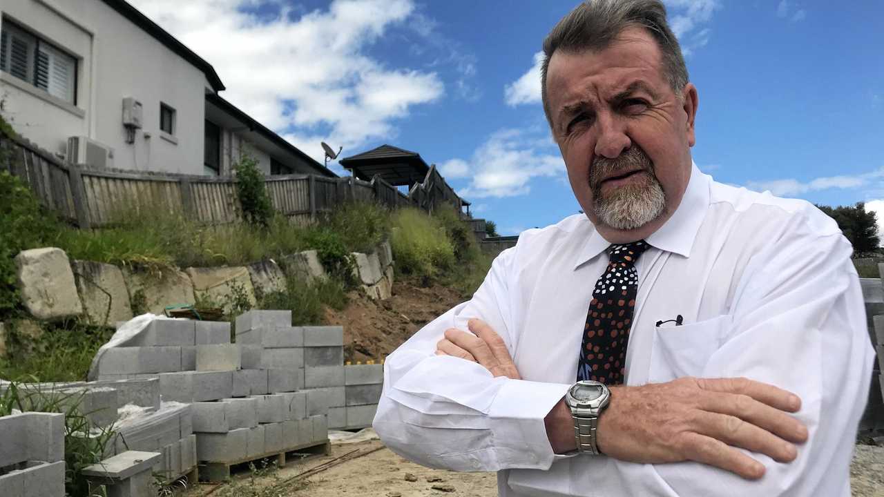 FALLING RISK: Councillor Paul Tully outside the Aristotle Street home that engineers say could slip into the excavation site below. Picture: Hayden Johnson