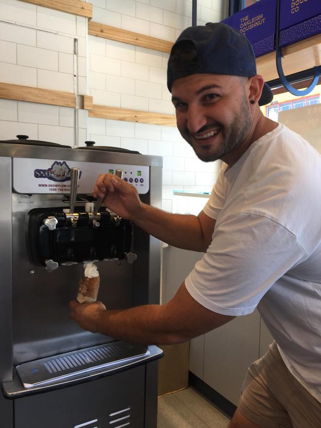 Oakleigh Doughnut Co co-owner Nic Kabylakis tries out the new doughnut ice cream cones.