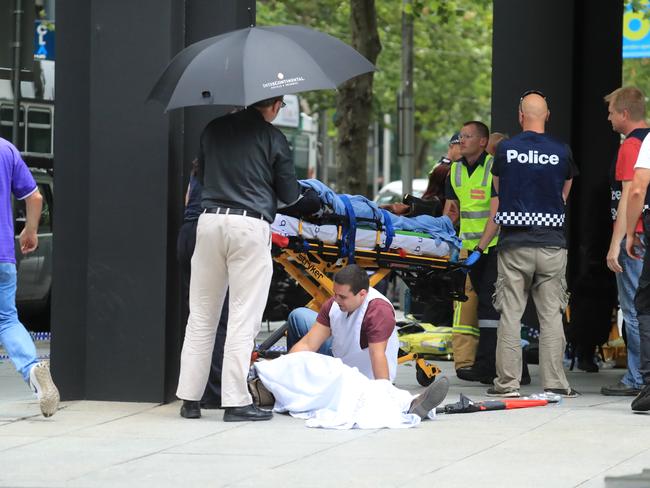 A man comforts a person on the footpath. Picture: Alex Coppel