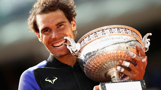 Rafael Nadal celebrates victory with the trophy following the mens singles final against Stan Wawrinka.