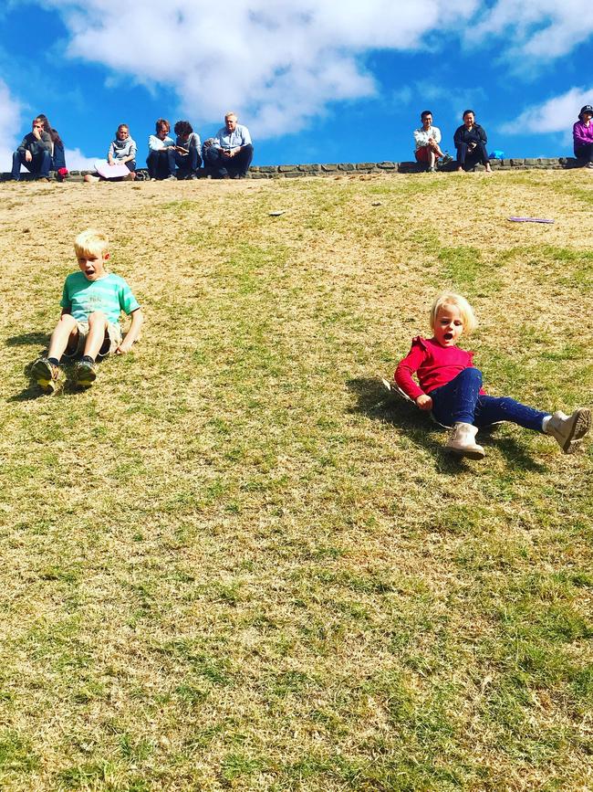 Sliding down the hill on cardboard sleds at the Mount Lofty Botanic Garden.