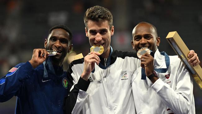 (FromL) Silver medallist US' Shelby McEwen, gold medallist Bahamas' Ian Kerr and bronze medallist Qatar's Mutaz Essa Barshim celebrate on the podium after competing in the men's high jump final of the athletics event during the Paris 2024 Olympic Games at Stade de France in Saint-Denis, north of Paris, on August 10, 2024. (Photo by MARTIN BERNETTI / AFP)