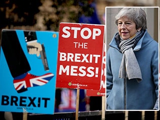 Protest signs and Theresa May.