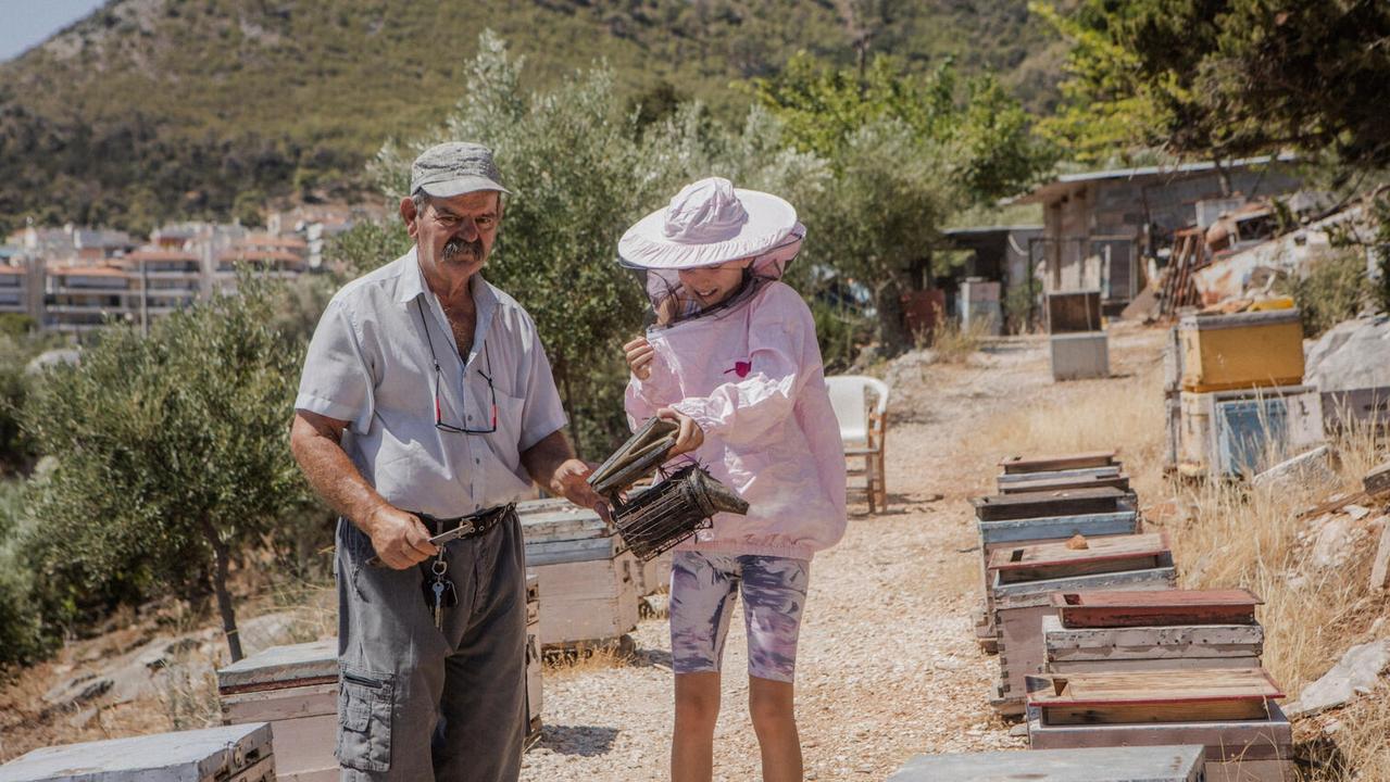 Markela helps her grandfather with the family’s beehives. Picture: UNICEF/Anna Pantelia