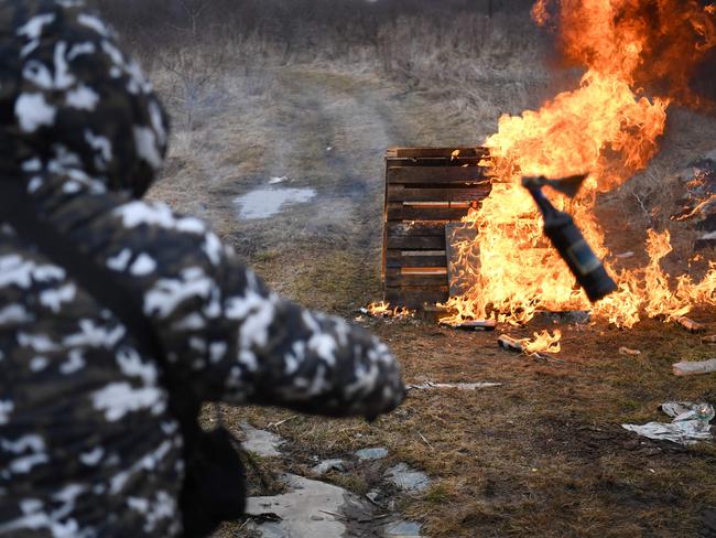 A man throws a Molotov cocktail during a self-defence civilian course on the outskirts of Lviv, western Ukraine. Picture: AFP.