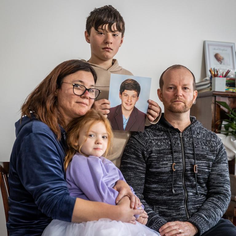 Lee-Ann and Matthew Elmes with their children Jemma and Aaron, holding a photo of Joshua. Picture: Jake Nowakowski