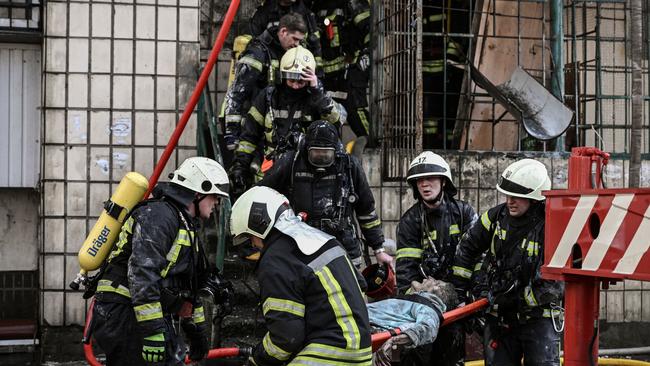 Firefighters remove the body of a woman out of a destroyed apartment building in Kyiv. Picture: AFP