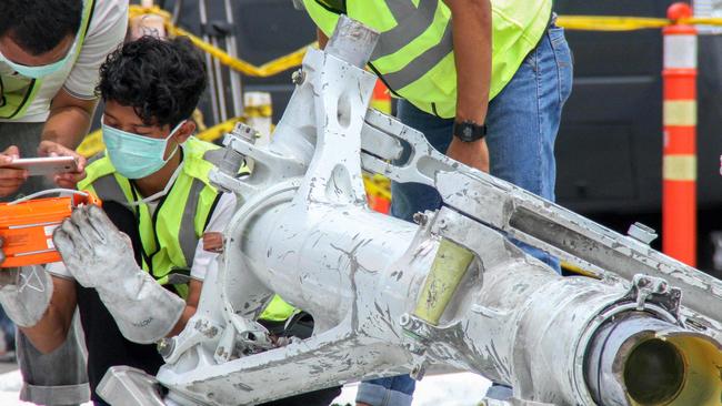 Investigators examine the landing gear of Lion Air flight JT610. Picture: AFP