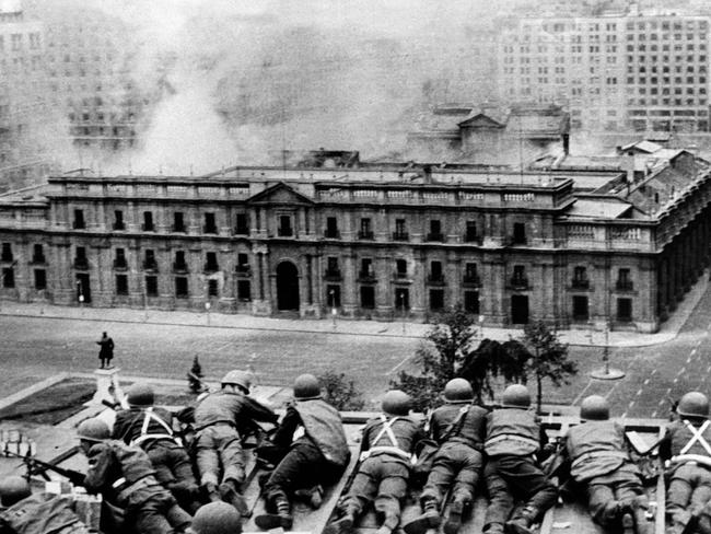 Chilean Army troops positioned on a rooftop fire on the La Moneda Palace on September 11, 1973.