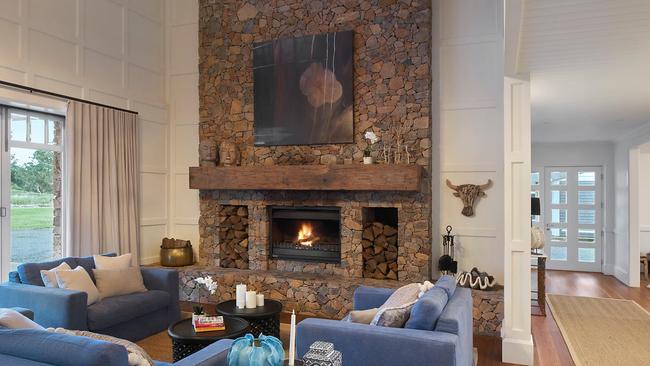 The main home features a two-storey drystone fireplace handmade from locally-quarried stone and an oversized hardwood mantle from old Sydney wharves. Picture: Supplied