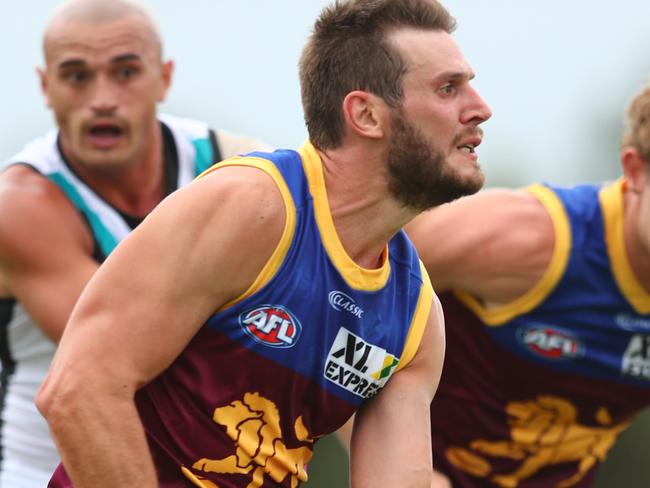 BRISBANE, AUSTRALIA - FEBRUARY 23: Grant Birchall of the Lions handballs during the 2020 Marsh Community AFL Series match between the Brisbane Lions and the Port Adelaide Power at Moreton Bay Sports Complex on February 23, 2020 in Brisbane, Australia. (Photo by Chris Hyde/AFL Photos/Getty Images)