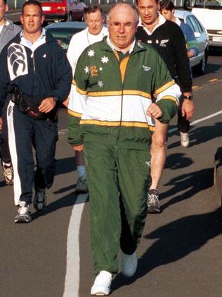 Then PM John Howard wears his trademark Wallabies tracksuit on a power walk in 1999.