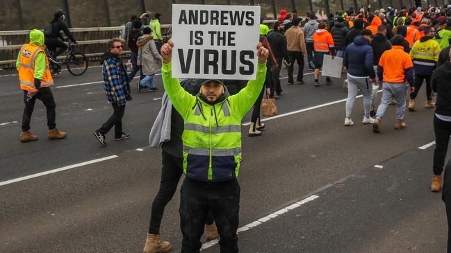 A protestor is seen holding a placard while protestors march down Westgate Bridge. Picture: Getty Images