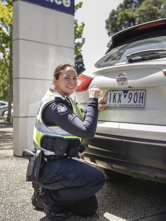 Senior Constable Bianca McKay installs safer screws on a car. Picture: Valeriu Campan