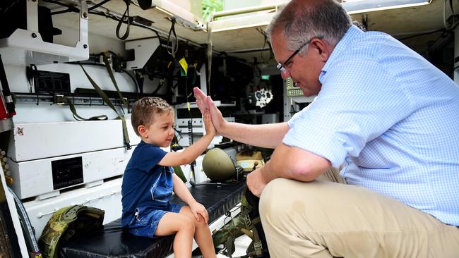 Prime Minister of Australia Scott Morrison visits Idalia in Townsville to survey the aftermath of the floods. Cooper Egan 3 having a tour of an M113 APC .Picture: Alix Sweeney