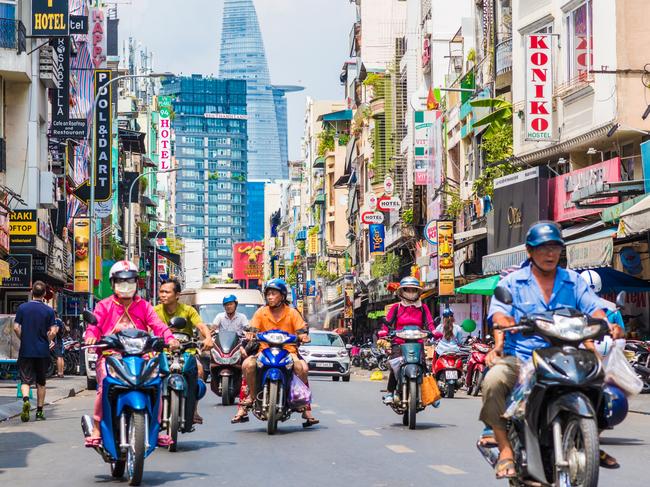 Bui Vien Street perspective, numerous signboards, people, motorbikes, Bitexco Tower. The colorful area is famous Saigon tourist attraction located in District 1, Ho Chi Minh City, Vietnam.Escape 16 July 2023Editors LetterPhoto - iStock