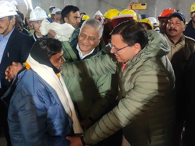 A contruction worker (front L) with India's Minister of State of Road Transport and Highways VK Singh (C) and Chief minister of Uttarakhand Pushkar Singh Dhami (R) following his rescue. Picture: Department of Information and Public Relation (DIPR) Uttarakhand / AFP