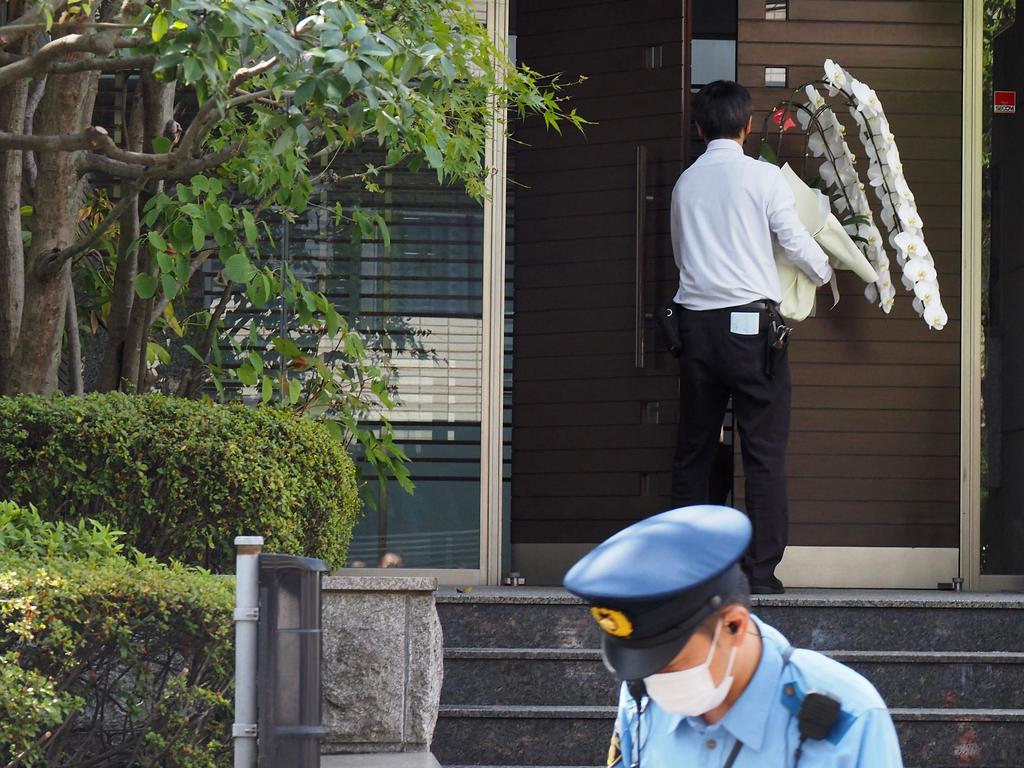 A man carries flowers at the residence of former Japanese prime minister Shinzo Abe in Tokyo on Saturday. Picture: AFP