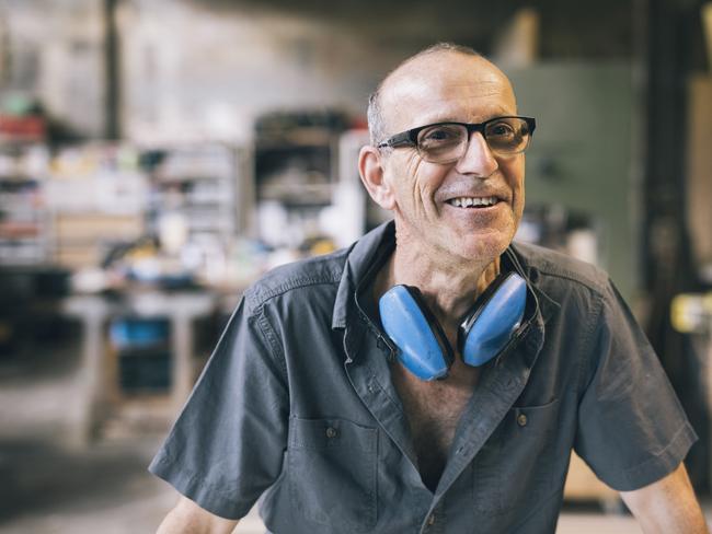 Candid portrait of factory  worker laughing; senior employee generic