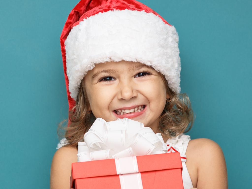 Happy little smiling girl with christmas present. Picture: iStock.