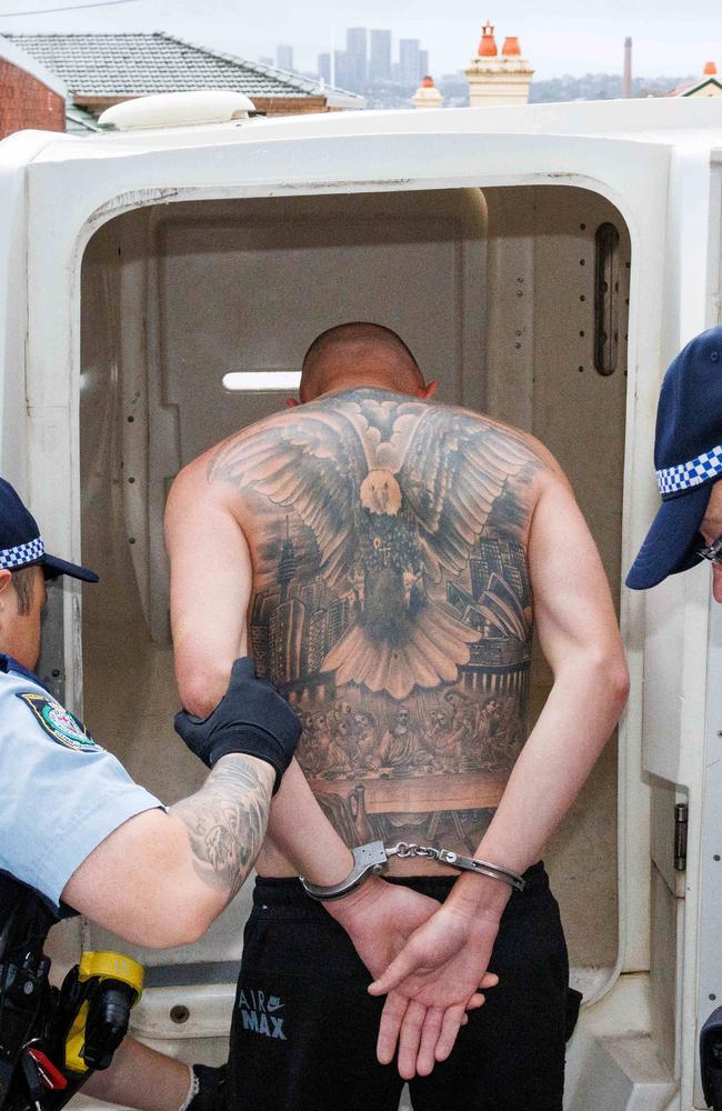 Saric, who has the Last Supper and Sydney Opera House tattooed on his back, is loaded into a police van after his arrest in Drummoyne on Wednesday morning. Picture: Max Mason-Hubers