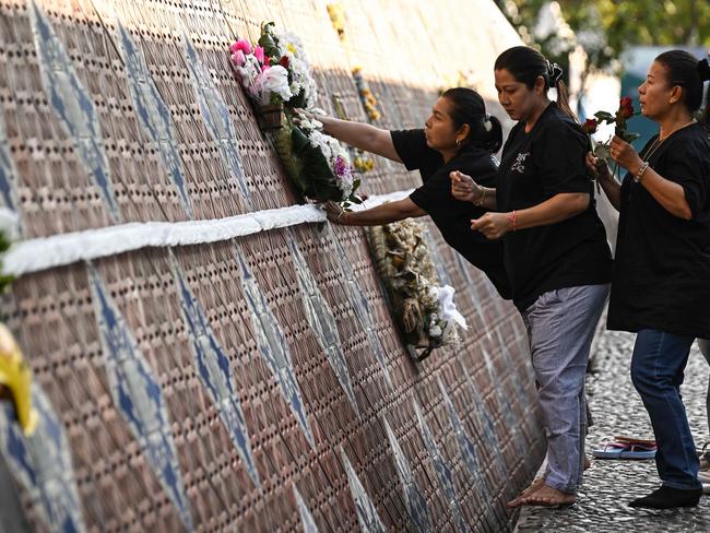 A family leaves flowers for their relatives at the Ban Nam Khem Tsunami Memorial in the southern Thai province of Phang Nga. Picture: AFP