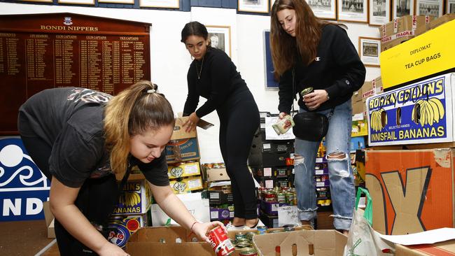 Volunteers Claudia Petukh, 16, Shahaf Pat, 16, and Sage Katz, 16, sort the tinned food donations. Picture: John Appleyard