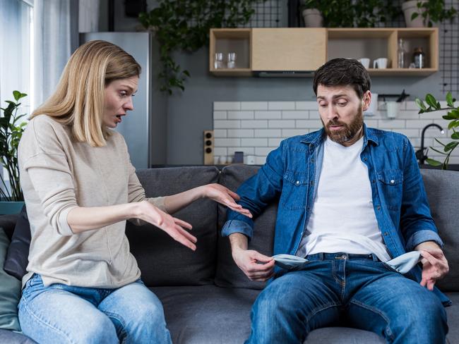 A young woman demands money from her husband, the man does not show empty pockets. At home, sitting on the couch. Quarrels, conflicts, misunderstandings. Money crisis; Money fighting, financial argument generic