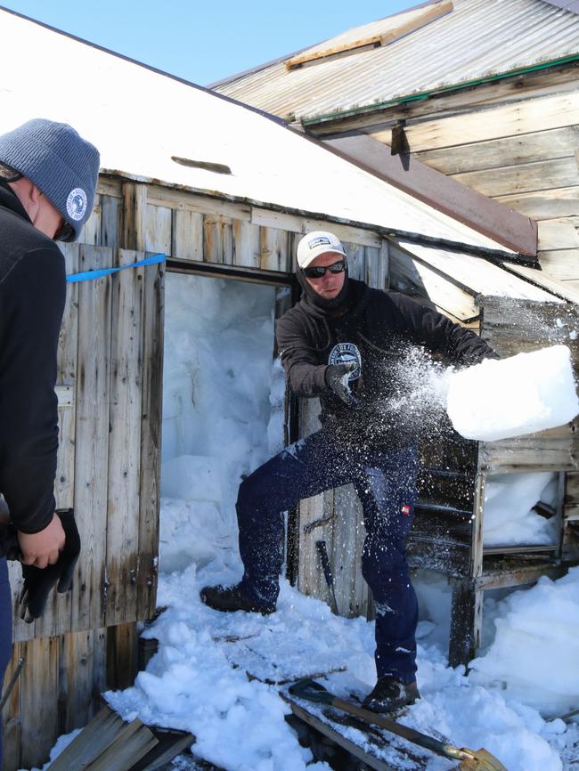 Expedition leader Marty Paassingham clears snow and ice from the entrance to Mawson's Hut to gain access to the interior passageway. Picture: David Killick