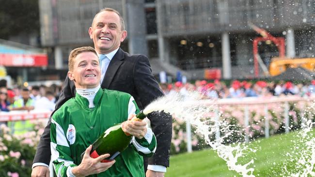 James McDonald sprays champagne as he celebrates with trainer Chris Waller. Picture: Vince Caligiuri/Getty Images