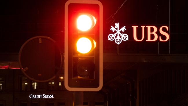 A sign of Credit Suisse bank is seen behind a sign of Swiss banking giant in Zurich. Switzerland's largest bank, UBS, is in talks to buy all or part of Credit Suisse. Picture: AFP