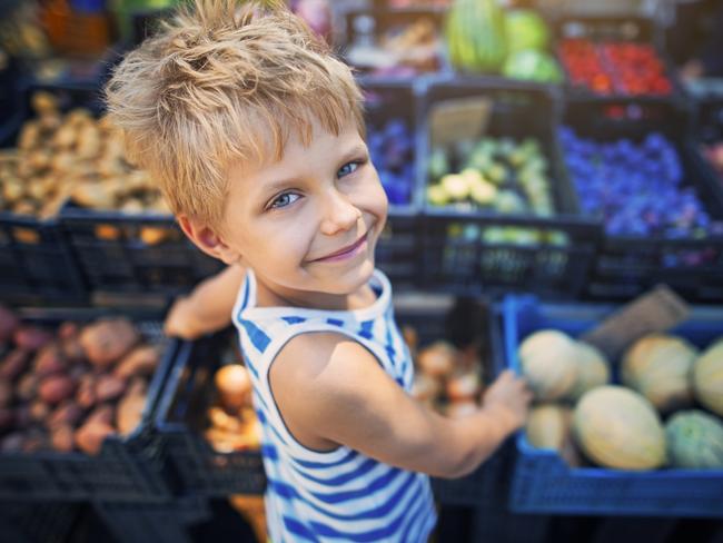 Happy little boy buying local groceries food at the tuscanian farmer's market at Cecina. Italy, Tuscany.  iStock generic markets shopping