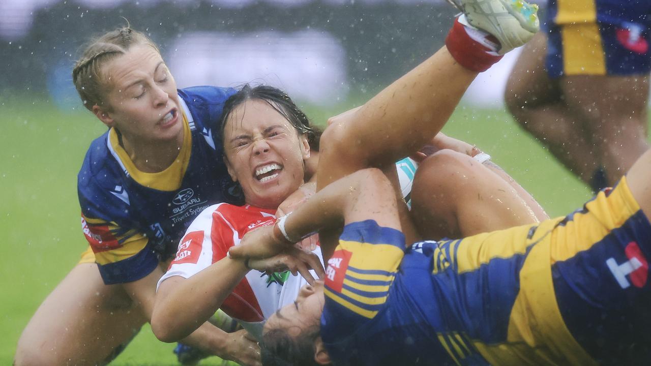 Tallish Fuimaono of the Dragons is tackled during the NRLW game played in driving rain.