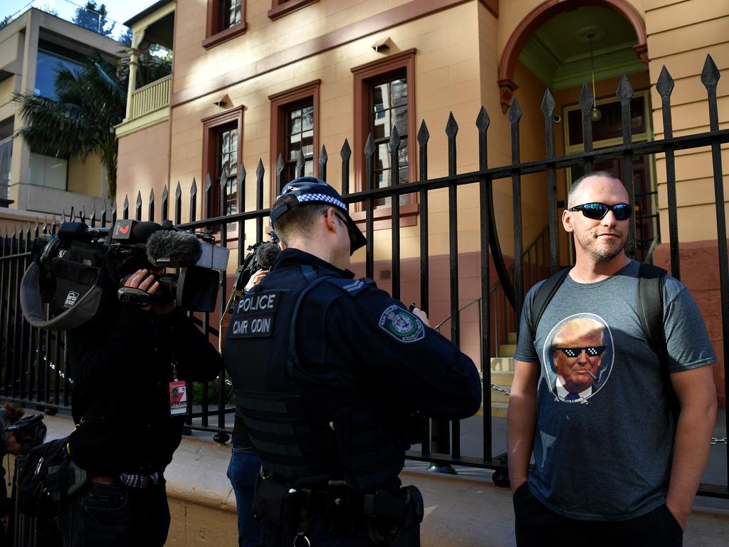 NSW Police speak to a man during a rally outside the New South Wales Parliament house in Sydney, Tuesday, August 6, 2019. (AAP Image/Joel Carrett)