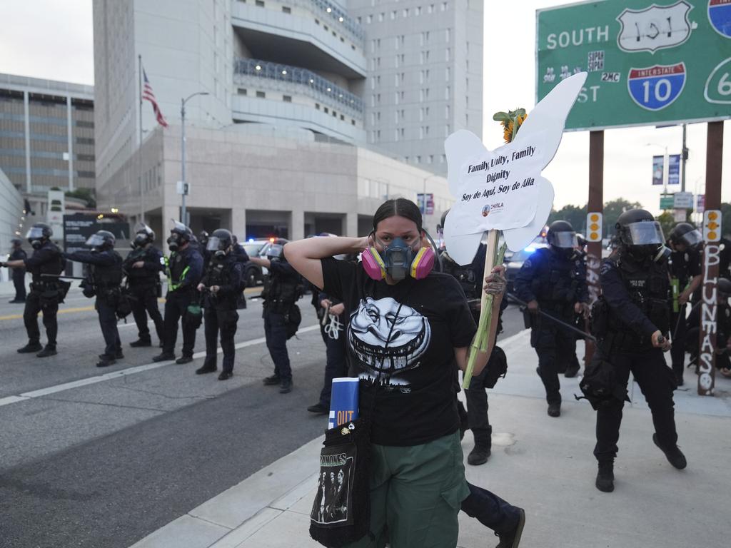 A protester stands in front of Los Angeles Police Department officers attempting to disperse a protest after federal immigration authorities conducted an operation. Picture: AP