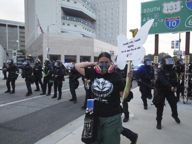 A protester stands in front of Los Angeles Police Department officers attempting to disperse a protest after federal immigration authorities conducted an operation. Picture: AP
