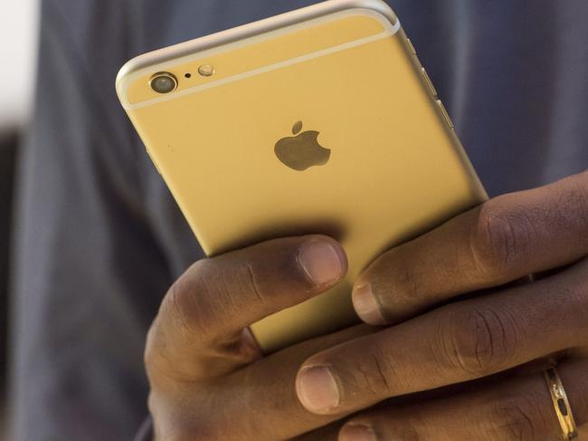 A customer holds an Apple iPhone 6s Plus at an Apple store in Palo Alto, California, in 2015. PHOTO: DAVID PAUL MORRIS/BLOOMBERG NEWS