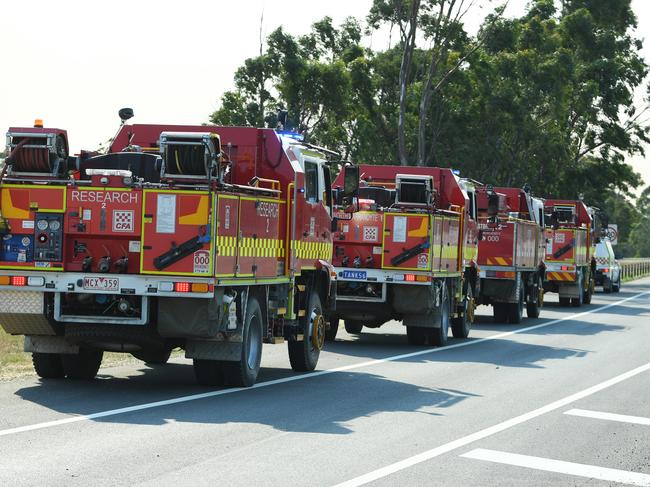 Fire Trucks stand by before deployment at a road closure checkpoint along the Princess freeway outside Pakenham Victoria, Sunday, March 3, 2019. The fires in Bunyip State Park started after lightning strikes on Friday afternoon, with 300 emergency workers deployed to fight the blazes. (AAP Image/James Ross) NO ARCHIVING