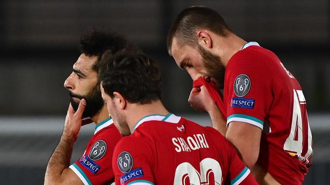 (L-R) Liverpool's Egyptian midfielder Mohamed Salah, Liverpool's Swiss midfielder Xherdan Shaqiri and Liverpool's English defender Nathaniel Phillips react at the end of the UEFA Champions League first leg quarter-final football match between Real Madrid and Liverpool at the Alfredo di Stefano stadium in Valdebebas in the outskirts of Madrid on April 6, 2021. (Photo by GABRIEL BOUYS / AFP)