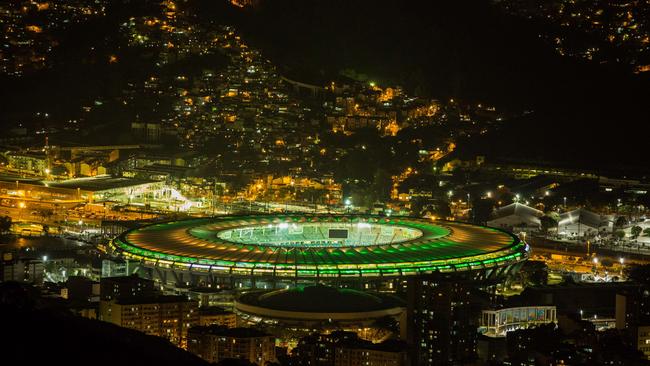 View of the Maracana Stadium illuminated in the Brazilian national flag's colours.