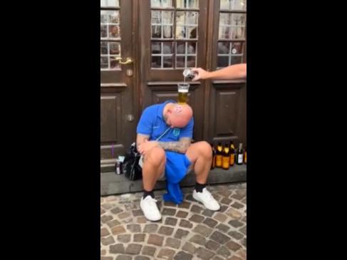 Blokes use a passed out man for a drinking game