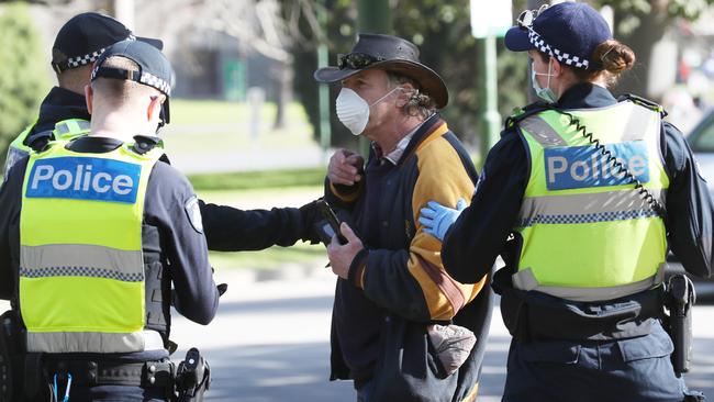 Police talk to a man near the shrine after an anti mask protest in July. Picture: NCA NewsWire