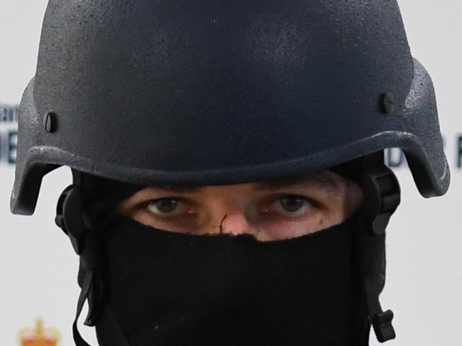 Australian Federal Police guard pseudo-ephedrine on a display table during a press conference at the Australian Federal Police headquarters in Melbourne, Monday, Jan. 9, 2017. A joint law enforcement operation has lead to the charging of five men and the seizure of up to 300 kg of pseudo-ephedrine hidden in a washing powder shipment. (AAP Image/Julian Smith) NO ARCHIVING