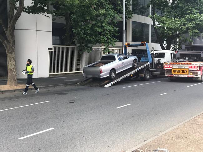 A ute is loaded on to a truck outside the Melbourne Remand Centre. Picture: Wes Hosking