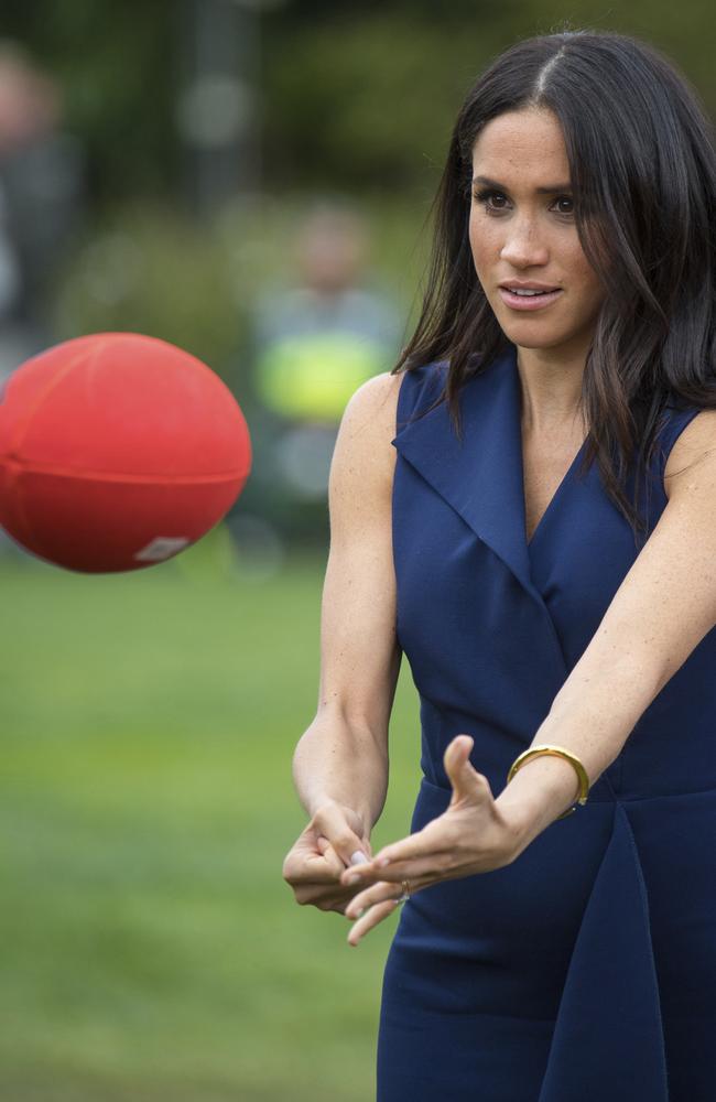 Meghan, Duchess of Sussex passes an Australian Rules football during an event at Government House in Melbourne. Picture: AP