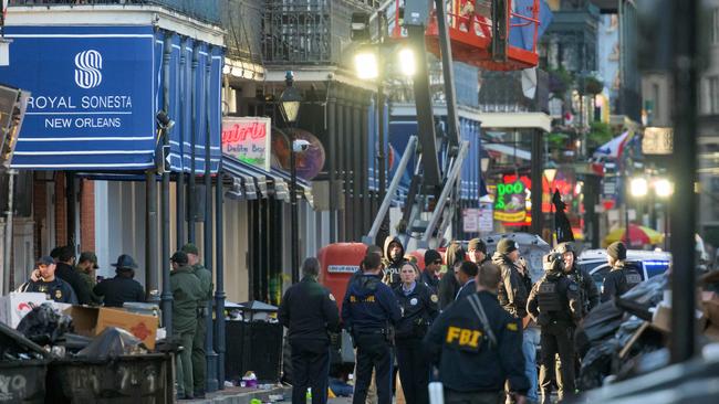 FBI investigators arrive at the scene where the white Ford F-150 pick-up truck crashed into a work lift after allegedly driving into a crowd of New Year's revellers. Picture: AFP.