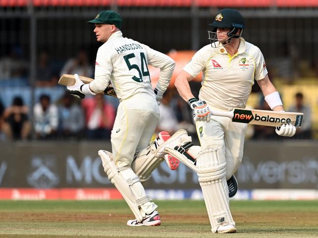 Australia's captain Steve Smith (R) and his teammate Peter Handscomb run between the wickets during the first day of the third Test cricket match between India and Australia at the Holkar Stadium in Indore on March 1, 2023. (Photo by Sajjad HUSSAIN / AFP) / ----IMAGE RESTRICTED TO EDITORIAL USE - STRICTLY NO COMMERCIAL USE-----