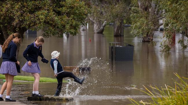 Bystanders watch the flooding along the shores of the port. Picture: Jason Edwards