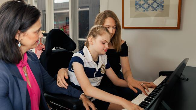 Josie plays the piano, one of her favourite activities, with her aunt Natasha Robinson and mum Sara Fishwick at their home in Penshurst. Picture: Max Mason-Hubers